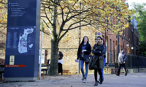 students walking past campus map